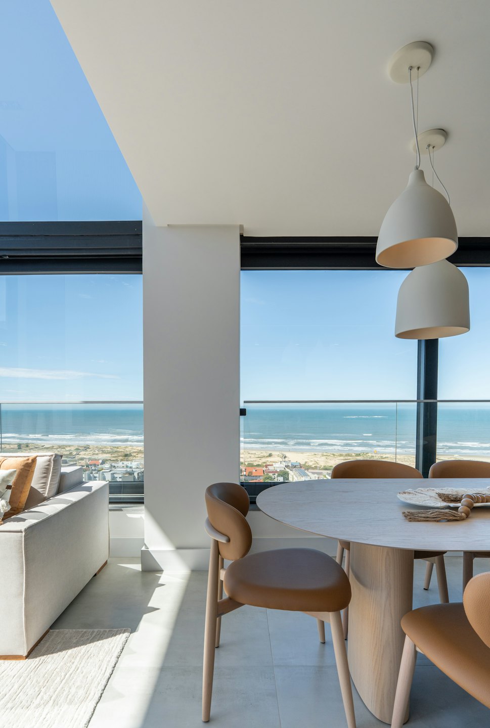 Modern apartment living area overlooking the ocean and coastal town.