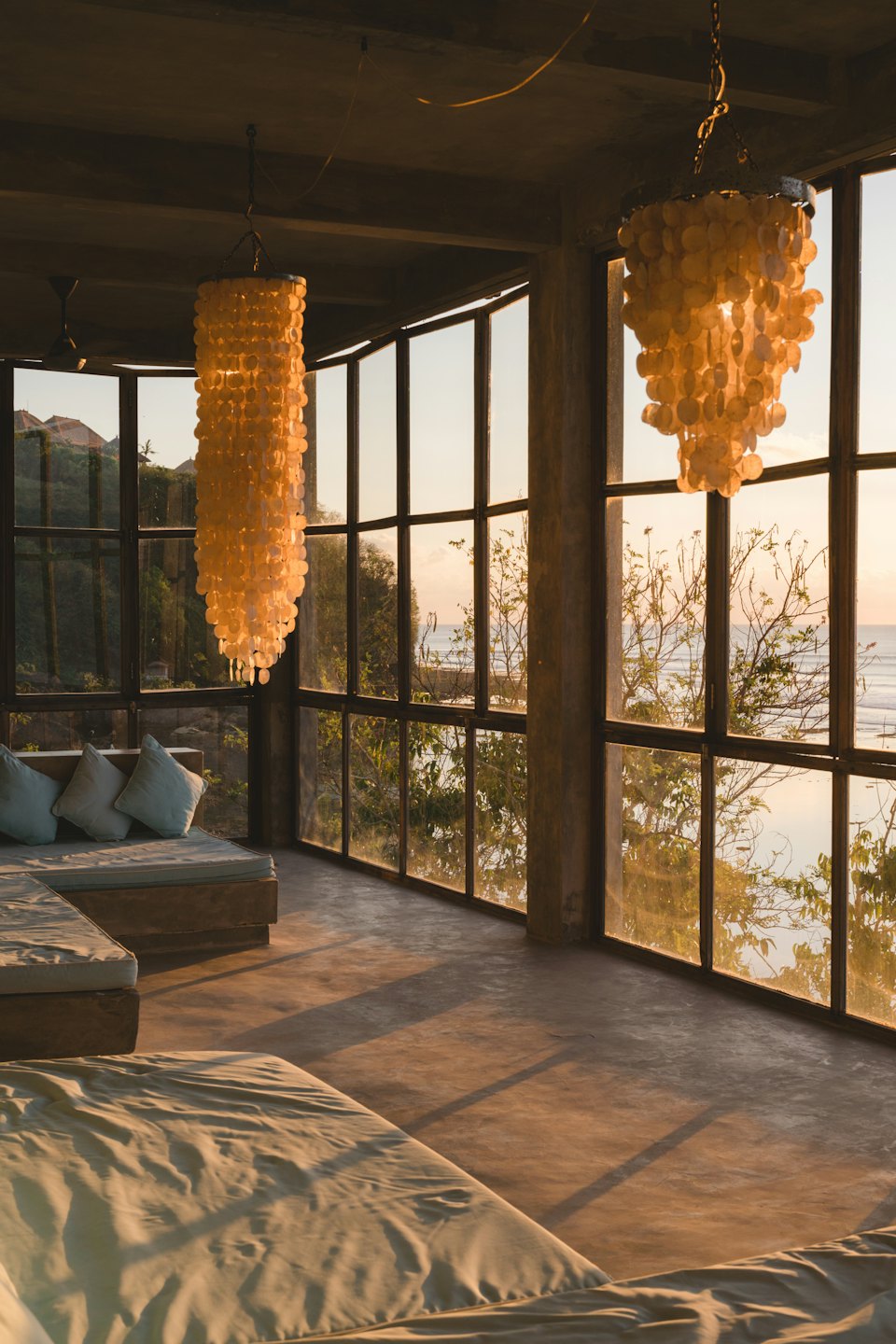 Daybeds in a room with large windows overlooking the ocean.